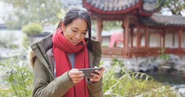 Çin Pavyonu bahçede Smartphone kullanan kadın