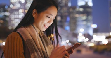 Smartphone şehirde gece kullanan kadın 