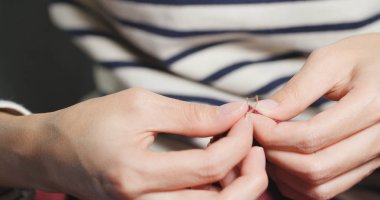 Kadın Sews bir iğne ve iplik el ile 