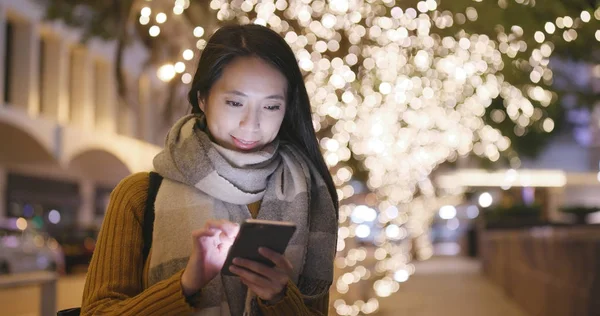 Gece kış zamanında Smartphone kullanan kadın 