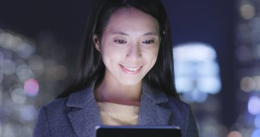 Geceleri tablet bilgisayar kullanan genç kadın 