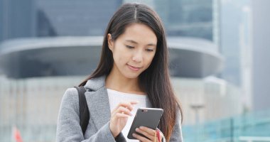 Şehirde akıllı telefon kullanan bir kadın