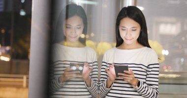 Pencere yansıması ile cep telefonu kullanan kadın 