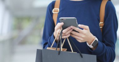 Cep telefonu ve çanta alışveriş tutar kullanarak kadın Gezgin 