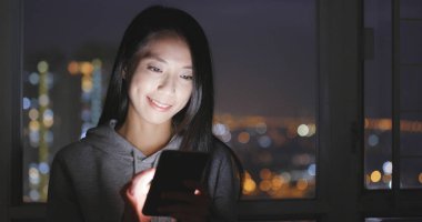 Geceleri Smartphone içinde izlerken kadın 