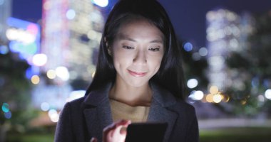 Asyalı kadın şehirde cep telefonu kullanarak 