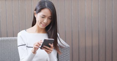 Elinde cep telefonu kullanan kadın