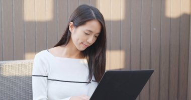 Açık kafede dizüstü bilgisayar üzerinde çalışan kadın 