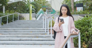 Smartphone kullanarak ve basamaklardan iniyor kadın