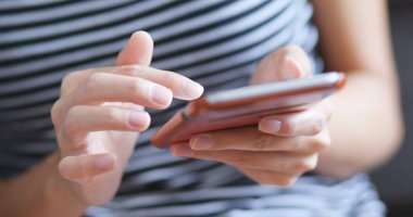 Evde cep telefonu kullanan bir kadın