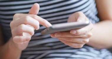 Evde cep telefonu kullanan bir kadın