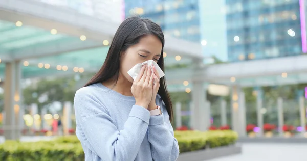 Woman sneeze at outdoor city