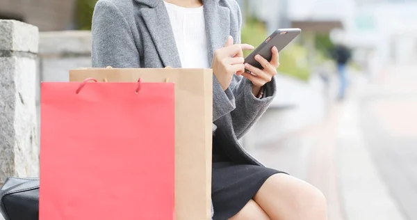 Frau Benutzt Handy Und Sitzt Mit Einkaufstasche — Stockfoto