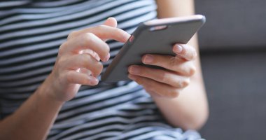 Evde akıllı telefon kullanan bir kadın. 