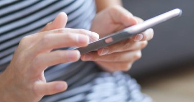 Evde akıllı telefon kullanan bir kadın. 