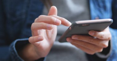 Evde cep telefonu kullanan bir kadın