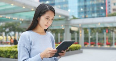 Açık, tablet bilgisayarda çalışan Asyalı kadın 