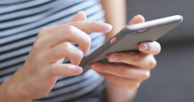 Evde cep telefonu kullanan bir kadın 