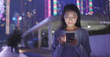 Kadın geceleri şehir smartphone bak 