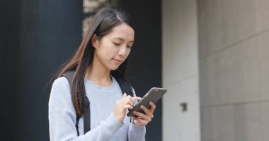 Şehirde akıllı telefon kullanan bir kadın 