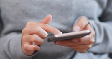 Evde cep telefonu kullanan bir kadın 