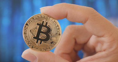 Bitcoin dijital arka plan üzerinde tutan el