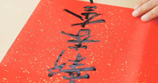 Writing Chinese calligraphy on write paper with phrase meaning happy new year