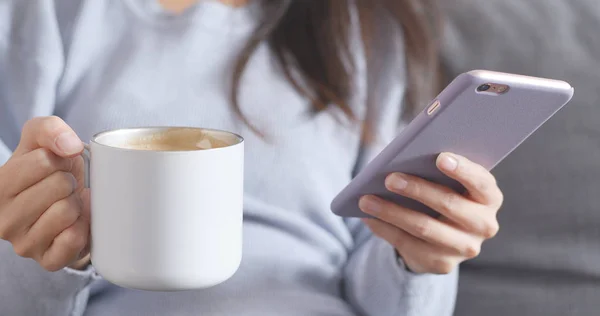 Vrouw Met Behulp Van Smartphone Houdt Van Warme Koffie — Stockfoto