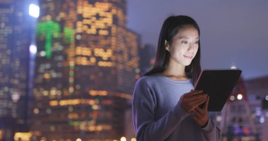 Geceleri dijital tablet bilgisayar kullanan kadın 