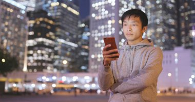 Adam cep telefonuyla şehirde geceleri 