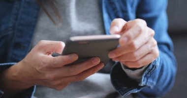 Evde cep telefonu kullanan bir kadın 