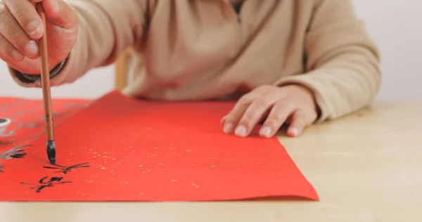 高齢者男書く赤い紙に中国の書道 — ストック写真