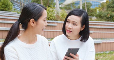 Kadın bir şey cep telefonu üzerinde arkadaşıyla paylaşmak