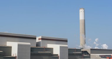 Duman ile fabrika yığını üzerinde mavi gökyüzü 