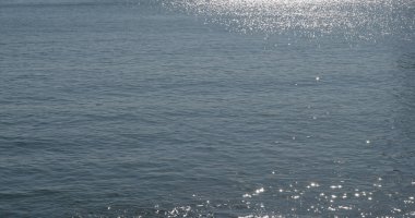 Su yüzeyi parlak güneşin altında dalgaları ile 