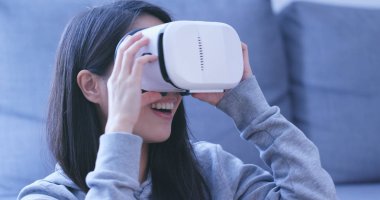 Sanal gerçeklik aygıtıyla gece izlerken kadın 