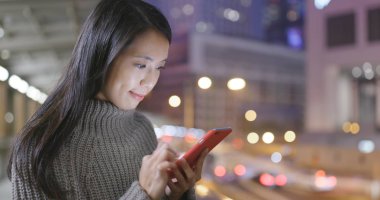 Geceleri cep telefonu kullanan bir kadın. 