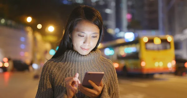 夜间在城市使用智能手机的妇女交通道路背景 — 图库照片