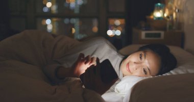 Cep telefonunuzun SMS gönderme ve yatakta yatarken kadın 