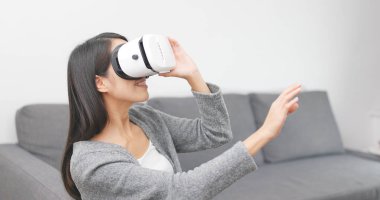 Evde VR aygıtla izlerken kadın 