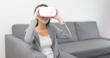 Evde VR aygıtla izlerken kadın 