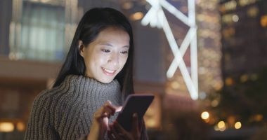 Geceleri cep telefonu kullanan bir kadın. 