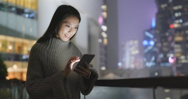 Geceleri cep telefonu kullanan bir kadın. 