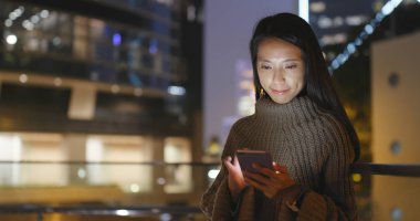 Gece akıllı telefon kullanan bir kadın.