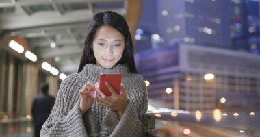 Geceleri cep telefonu kullanan bir kadın. 