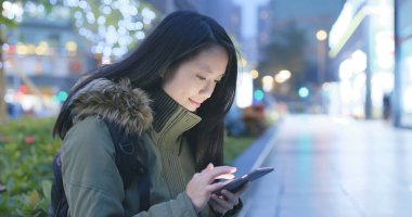 Smartphone şehirde geceleri kullanan kadın 