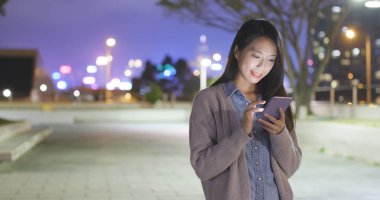 Akıllı telefon kullanan genç bir kadın. 