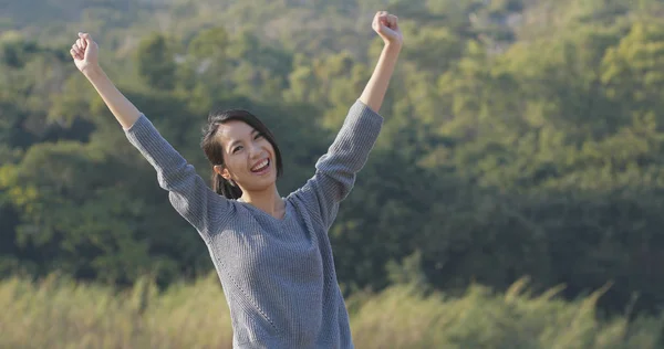 Excited woman raising hand up
