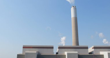 Endüstriyel fabrika baca ve duman mavi gökyüzü üzerinde 