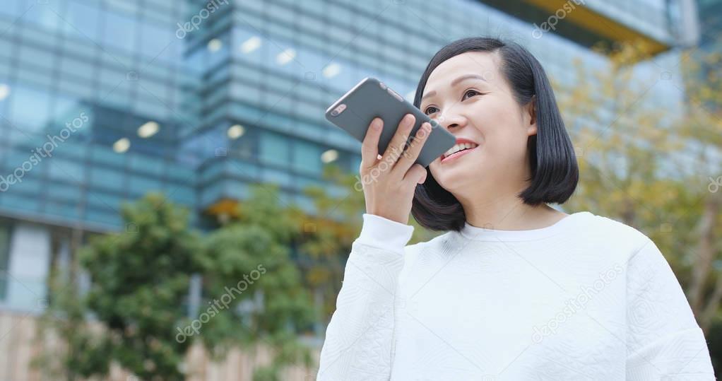 Woman sending audio message on cellphone 